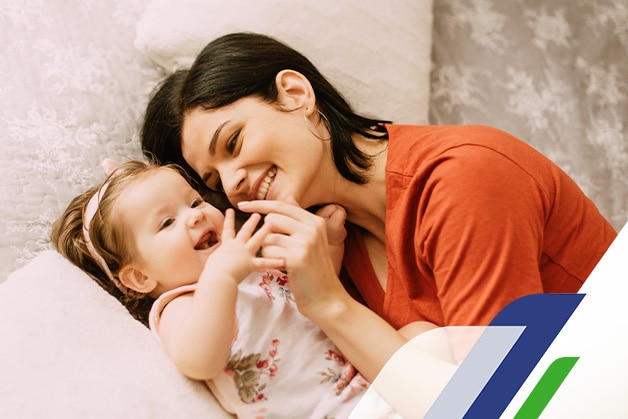 Mãe sorrindo junto ao seu bebê  