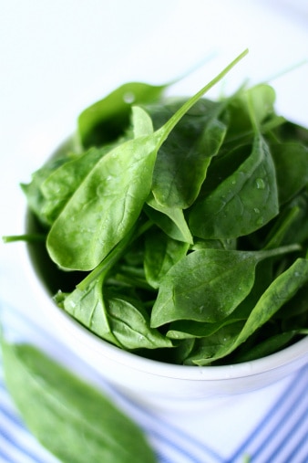 Uma tigela branca com salada e espinafre, uma ótima fonte de vitamina E