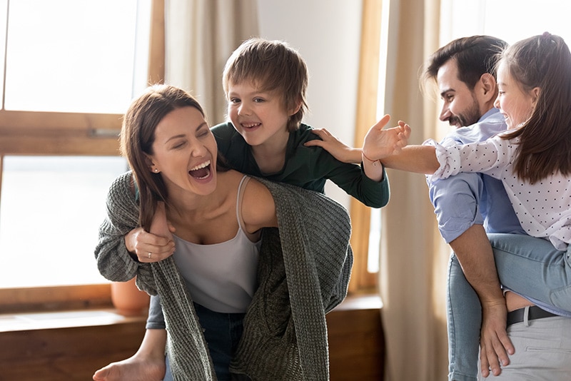 Pai e mãe brincando com seus dois filhos depois de aprender como fazer massinha