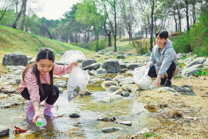 Lobinhos recolhendo lixo de um rio raso e calmo 