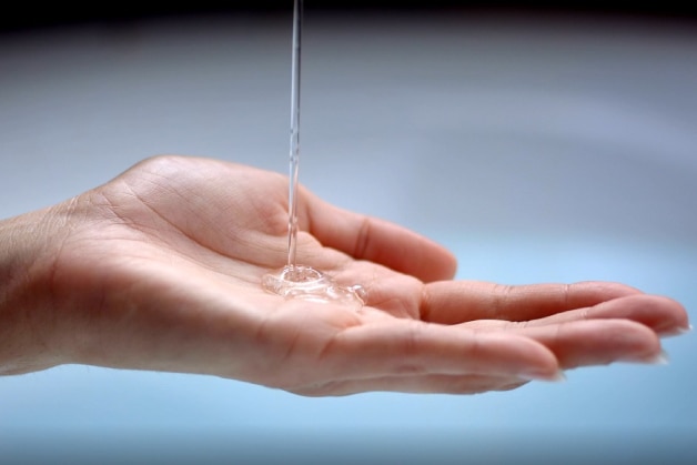 Mão com sabonete líquido transparente, simbolizando a importância do sabonete íntimo para a higiene íntima suave, segura e equilibrada.