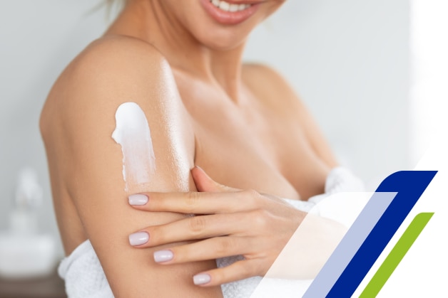 uma mulher passando hidratante no braço e sorrindo