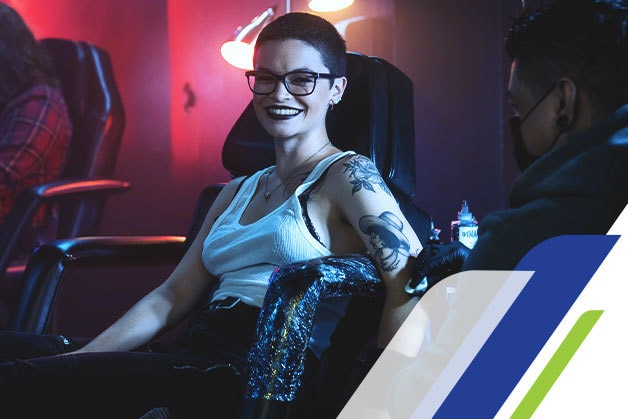 Mulher fazendo uma tattoo em um estúdio de tatuagem 