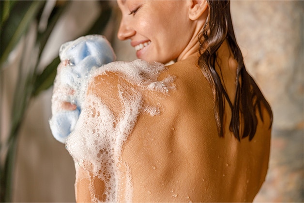 Mulher tomando um banho com o sabonete refrescante Protex, que oferece proteção prolongada.