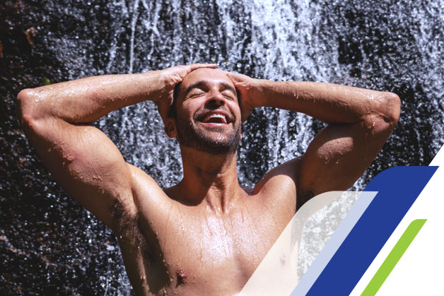 Homem na beira da cachoeira tomando banho e cuidando da sua pele masculina 