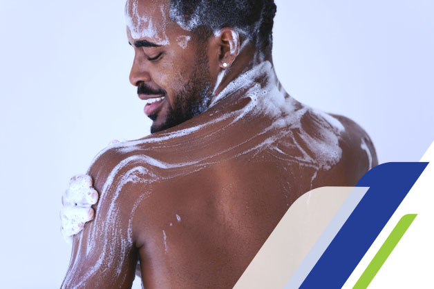 Homem de costas tomando banho e se ensaboando com sabonete neutro antibacteriano
