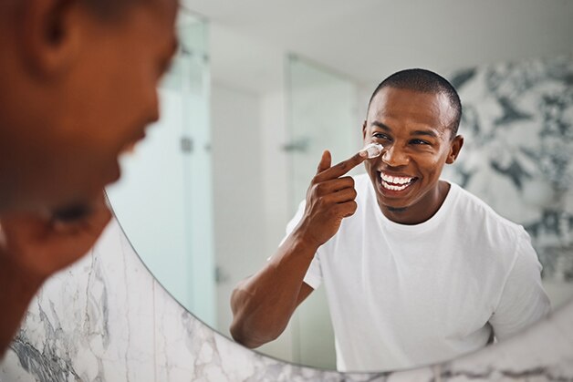 homem aplicando protetor solar no rosto sorrindo homem aplicando protetor solar no rosto sorrindo