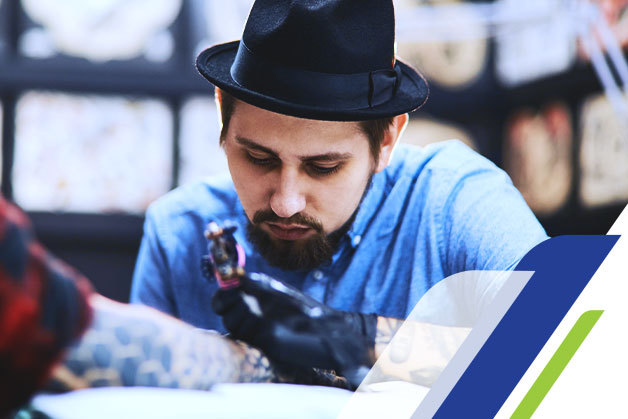 Tatuadores de qualidade: profissional fazendo uma tatuagem em um cliente Tatuadores de qualidade: profissional fazendo uma tatuagem em um cliente